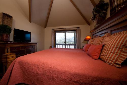 Schlafzimmer mit einem Bett, einem TV und einem Fenster in der Unterkunft Cascade Village 56 in Durango Mountain Resort