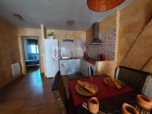 a kitchen with a dining table and a kitchen with a white refrigerator at El Ático de Mijares in Mijares