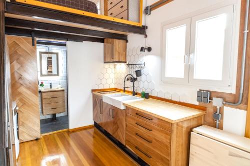 kuchnia z drewnianymi szafkami i zlewem w obiekcie Tarifa Cozy House - Tiny House w mieście Tarifa