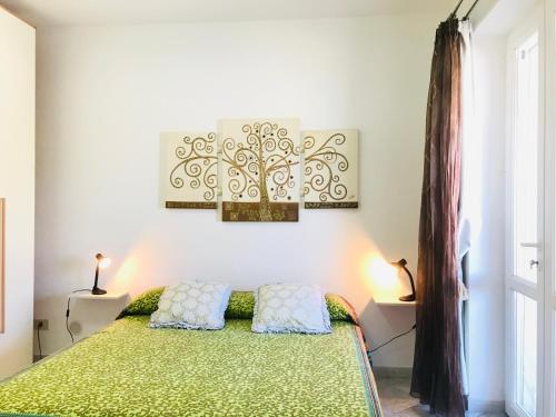 a bedroom with a green bed with two pillows at Pausa mare Ponza - Immobilevante in Ponza