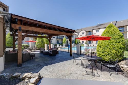 a patio with a table and chairs and an umbrella at Club Hotel Nashville Inn & Suites in Nashville