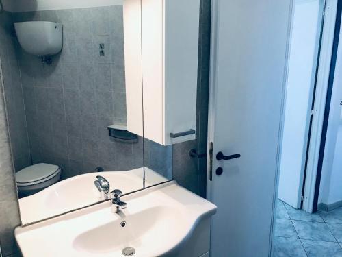 a bathroom with a sink and a toilet and a mirror at Pausa mare Ponza - Immobilevante in Ponza