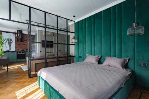 Un dormitorio con una pared verde y una cama en Апартаменты на Большом Фонтане 2, en Odessa