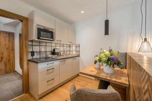 a kitchen with white cabinets and a wooden table at Meerberg in Pertisau