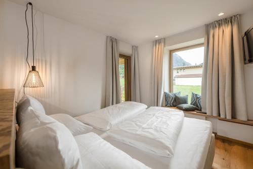 a white bed in a room with a window at Meerberg in Pertisau