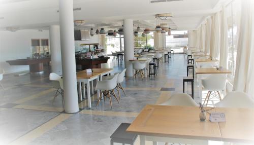 a row of tables and chairs in a restaurant at Hotel Vasco Da Gama in Monte Gordo