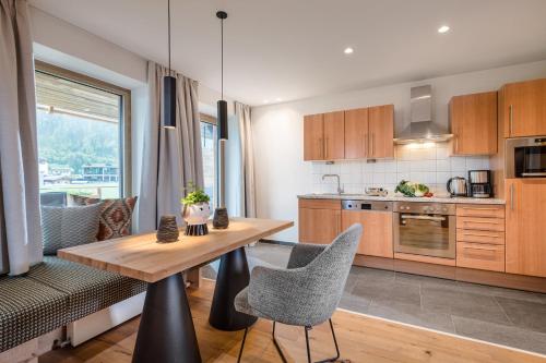 a kitchen with a wooden table and some chairs at Meerberg in Pertisau