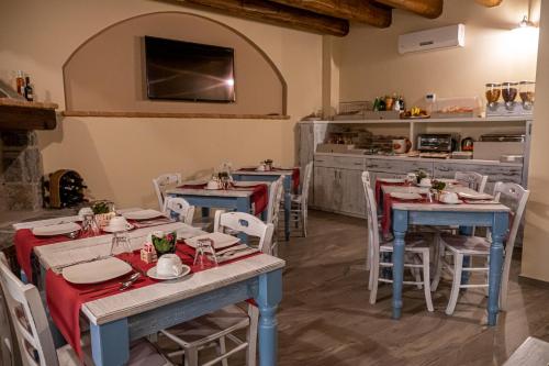 a dining room with tables and chairs and a kitchen at Dimora Del Corso in Rotonda
