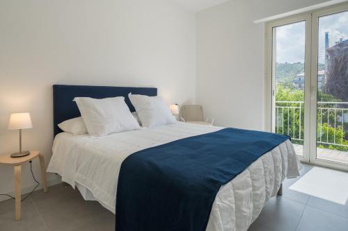 um quarto com uma cama azul e branca e uma janela em Marèe b&b em Agropoli
