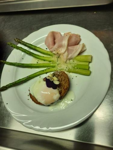 a plate of food with asparagus and a flower on it at Hotel Gran Pre in San Vigilio Di Marebbe
