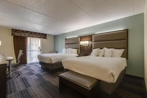 a hotel room with two beds and a desk at Club Hotel Nashville Inn & Suites in Nashville