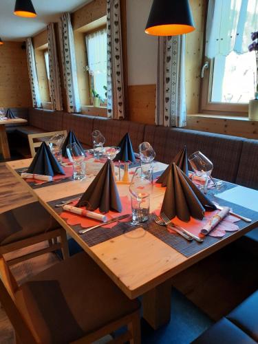 a long wooden table with glasses and napkins on it at Hotel Gran Pre in San Vigilio Di Marebbe
