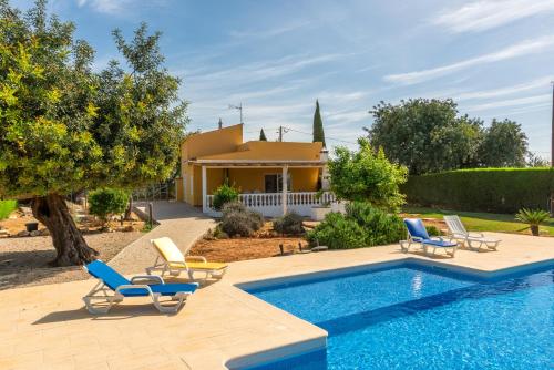 a villa with a swimming pool and a house at Holiday's Paradise in Olhão