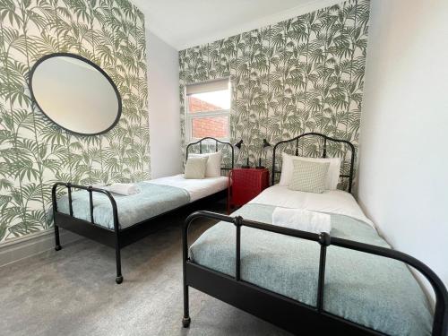 a bedroom with two beds and a mirror at Great located Victorian house with all amenities in Bristol