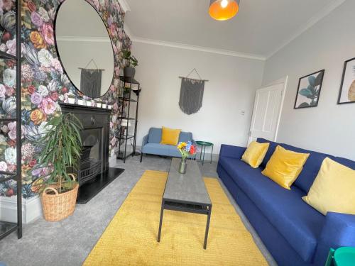 a living room with a blue couch and a mirror at Great located Victorian house with all amenities in Bristol