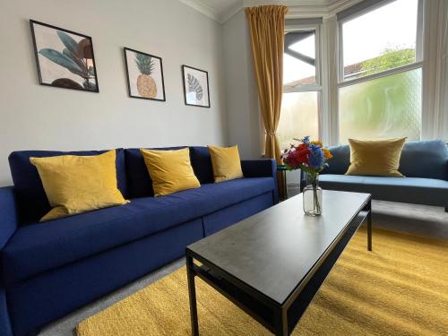 a living room with a blue couch and a coffee table at Great located Victorian house with all amenities in Bristol