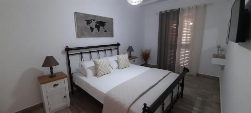 - une chambre avec un lit doté de draps et d'oreillers blancs dans l'établissement Alisachni, à Kinion