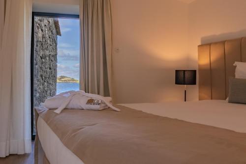 a hotel room with a bed with a view of the ocean at Portas do Ilhéu in Praia da Graciosa