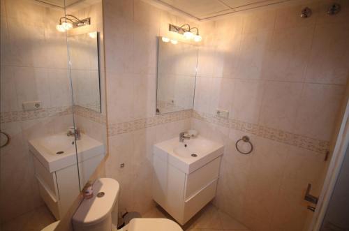 a bathroom with a toilet and a sink and a mirror at POSTIGUET BEACH in Alicante