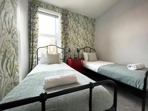 1 Schlafzimmer mit 2 Betten und einem Fenster in der Unterkunft Great located Victorian house with all amenities in Bristol
