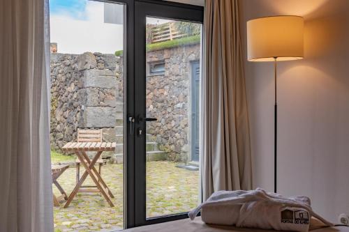 sypialnia z drzwiami otwierającymi się na patio w obiekcie Portas do Ilhéu w mieście Praia da Graciosa