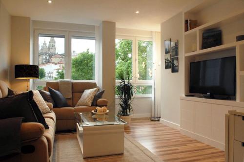 Silver Home في سانتياغو دي كومبوستيلا: غرفة معيشة مع أريكة وتلفزيون بشاشة مسطحة