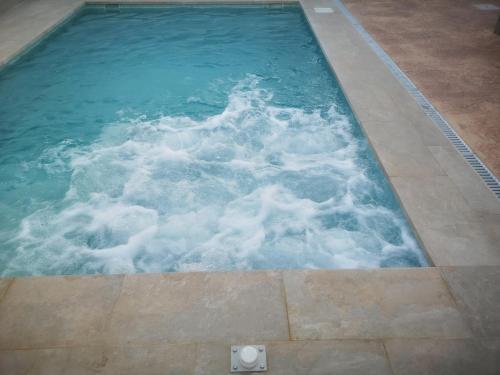 a swimming pool with blue water and white foam at Casita Rural CONIL in Conil de la Frontera