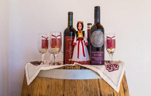 a group of wine bottles and glasses on a table at Apartman Ana Marija in Gruda