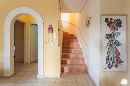 a hallway with a staircase with a painting of a woman at Lavender Garden Retreat - Secluded Seaside Getaway in Kotrónion
