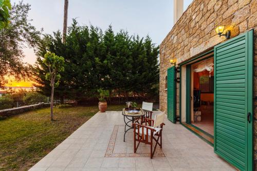 a patio with a table and chairs next to a building at Lavender Garden Retreat - Secluded Seaside Getaway in Kotrónion