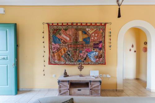 a tapestry hanging on a wall with a table at Lavender Garden Retreat - Secluded Seaside Getaway in Kotrónion
