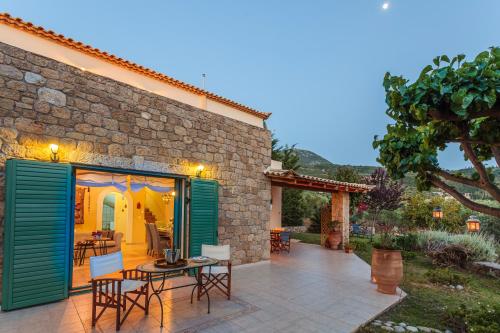 a patio with a table and chairs in front of a building at Lavender Garden Retreat - Secluded Seaside Getaway in Kotrónion