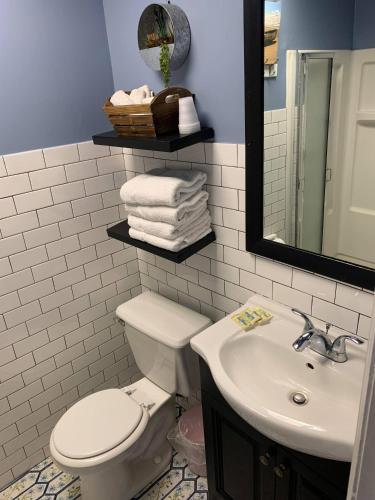 a bathroom with a toilet and a sink and a mirror at Ocean Manor 1100 Inn in Ocean City