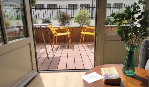 a door leading to a patio with chairs and a table at Appart hôtel & Spa La Villa du Port in Vannes