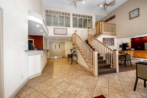 a living room with a staircase and a kitchen at Red Roof Inn Clifton Park in Clifton Park