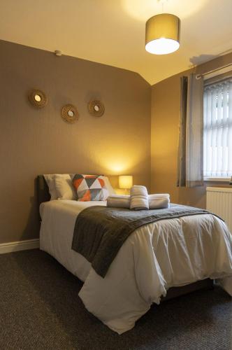 a bedroom with a large bed with white sheets and pillows at Abercorn Place Entire House 4 Bedrooms in Scunthorpe