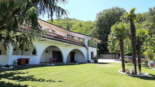 un edificio con palme di fronte a un cortile di "CARA PACE" in collina per famiglie a Montefiore Conca