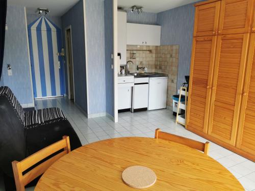 - une cuisine et une salle à manger avec une table en bois dans l'établissement Studio Le Cécile, au Croisic