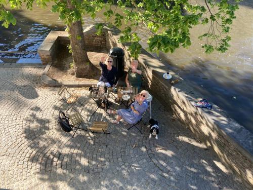 two women sitting at a table next to the water at Canal Central in Bruges