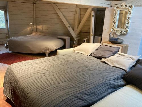 a bedroom with two beds and a mirror on the wall at Canal Central in Bruges
