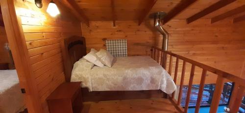 a room with a bed in a wooden cabin at Cabaña las trancas in Nevados de Chillan