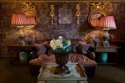 a living room with a couch and a table with flowers at Prestonfield House in Edinburgh