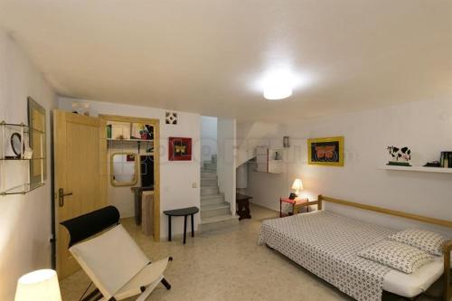 a bedroom with a bed and a chair in it at ADOSADO DE LUJO CON PISCINA PRIVADA en ZONA MUY TRANQUILA in Gandía