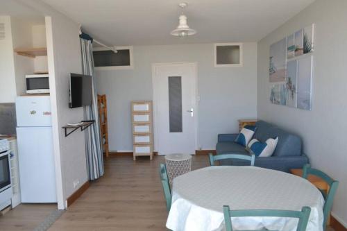 une cuisine et un salon avec une table et des chaises dans l'établissement Appartement studio vue mer les pieds dans l'eau, à Saint-Jean-de-Monts