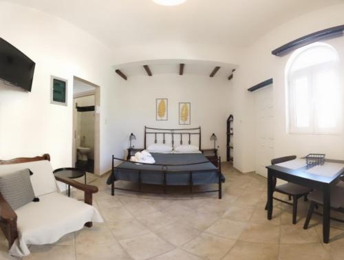 a bedroom with a bed and a couch and a table at Xanthi Apartments in Syvota