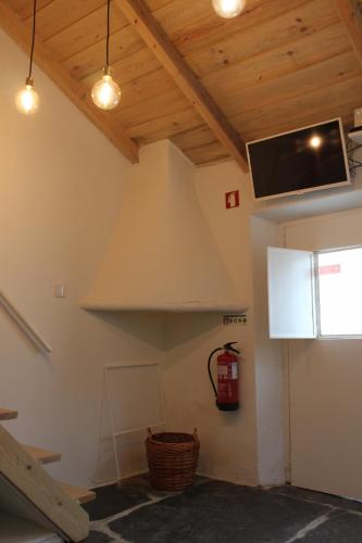 a living room with wooden ceilings and a tv at Alma d'Outeiro in Monsaraz
