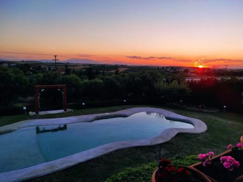 a swimming pool with a sunset in the background at Villa Traditional Estate Heated Pool & Garden, 5 bedrooms in Metókhion Patriotikón