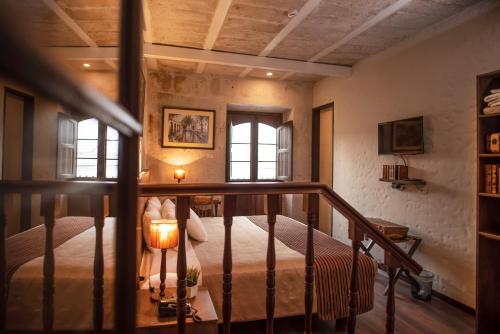 a bedroom with a bed with a lamp and windows at Acolpacha Tambo Boutique in Arequipa