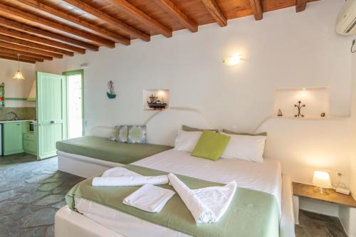 two beds in a room with white walls at Parathyro sto Aigaio 2 - Small Suites in Tinos Town