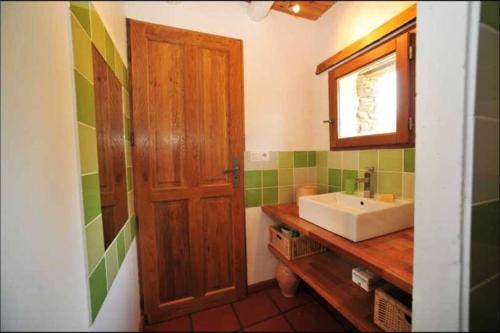 a bathroom with a sink and a wooden door at Charmant Mas tout équipé en pleine nature catalane in Cases-de-Pène